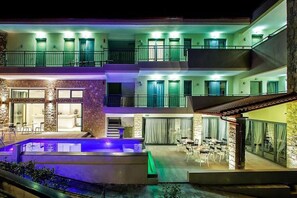 A multi-story hotel with a swimming pool, outdoor seating, and balconies. - Core Hotel (Kassandra)