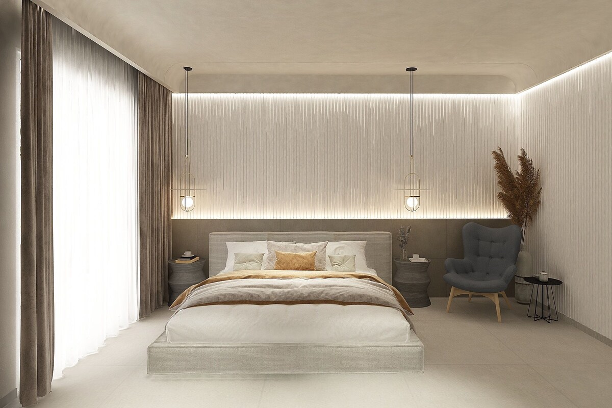 A modern bedroom with a large bed, bedside tables, a chair, and a decorative plant.