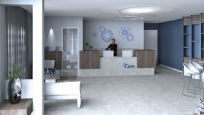 Ein Empfangsbereich mit Rezeptionistin, Empfangstresen, einer Sitzbank und einer Wand mit dekorativen Mustern.