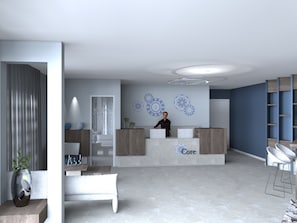 A reception area with a receptionist, a reception desk, a bench, and a wall with decorative patterns. - Core Hotel (Kassandra)
