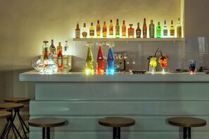 A bar area with a variety of liquor bottles and colorful glasses on display. - Core Hotel (Kassandra)
