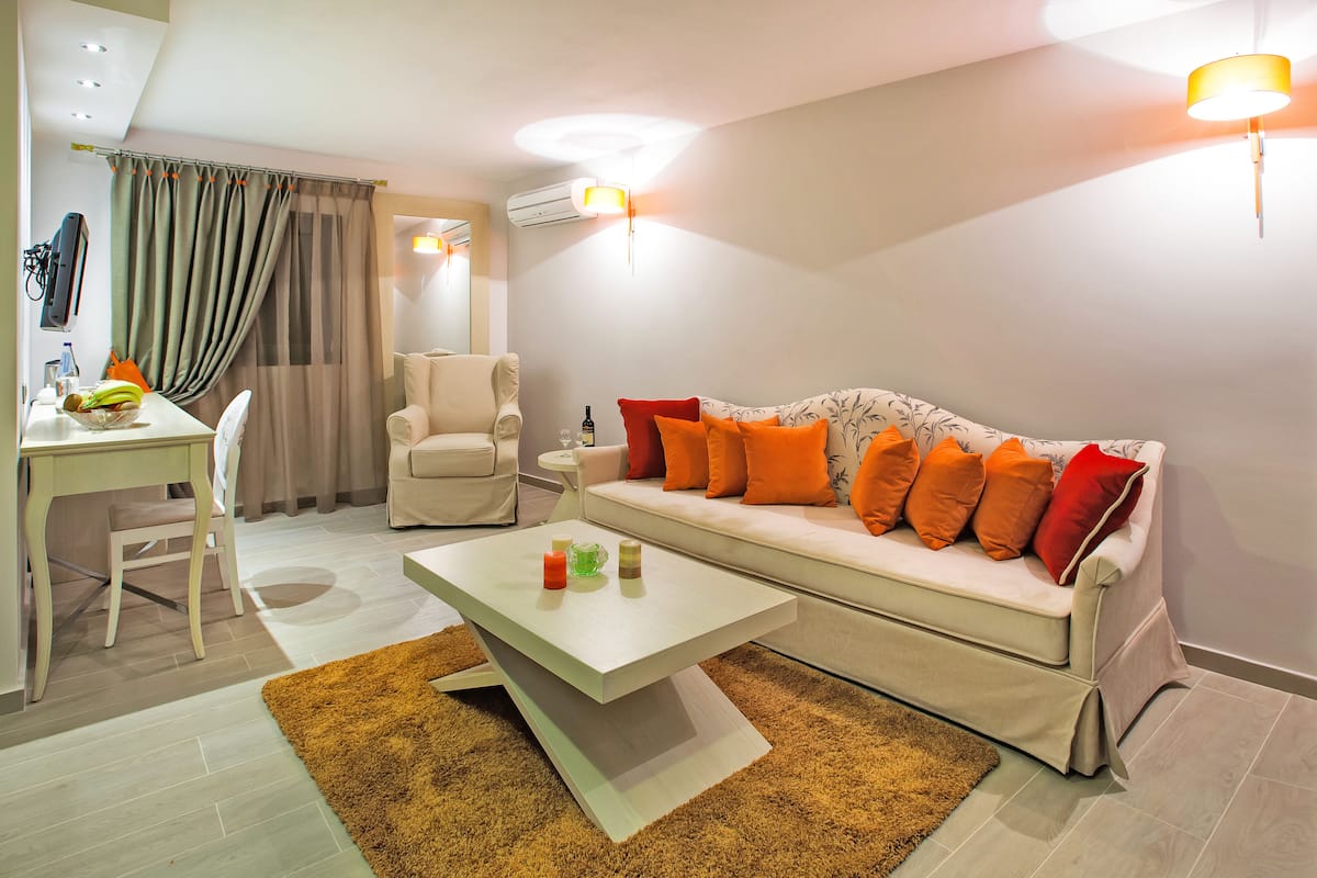 A modern living room with a sofa, coffee table, and a dining area with a chair and table.