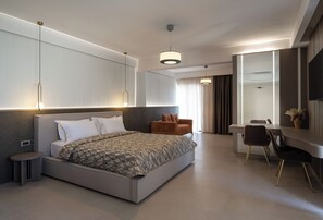 A modern bedroom with a large bed, a desk, and a chair. - Core Hotel (Kassandra)