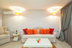 A living room with a sofa, a coffee table, and a lamp. - Core Hotel (Kassandra)