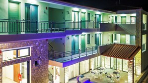 Ein mehrstöckiges Hotel mit Balkonen, einem Poolbereich und einem Essbereich.