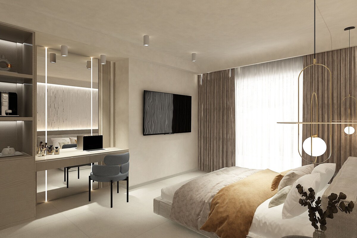 Un dormitorio moderno con cama, escritorio, silla y un gran ventanal con cortinas.