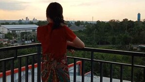 A person standing on a balcony with a view of a cityscape and greenery. - Bukit Indah Lestari Hotel (Tanjung Baru)