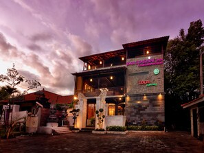 A two-story building with a sign for 'Bali Sunshine Inn & multicuisine restaurant' and 'UDOPI pure veg'.