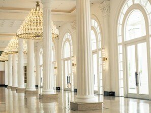Un interior espacioso con techos altos, amplias ventanas de arco y múltiples candelabros.