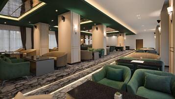 A hotel lobby with a central seating area, a reception desk, and a bar.