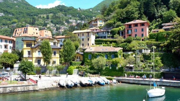 A coastal town with colorful buildings, a marina with boats, and a hillside backdrop. - Vacation home Giò by Interhome (Varenna)