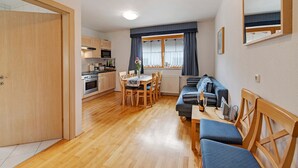 A compact living space with a kitchen, dining area, and seating area. - "Haus Lowe Appartement 1 Stock Nr 2" with Mountain View (Filzmoos)