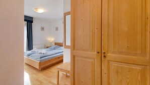 A bedroom with a wooden bed, a bedside table, and a wardrobe. - "Haus Lowe Appartement 1 Stock Nr 3" with Mountain View (Filzmoos)