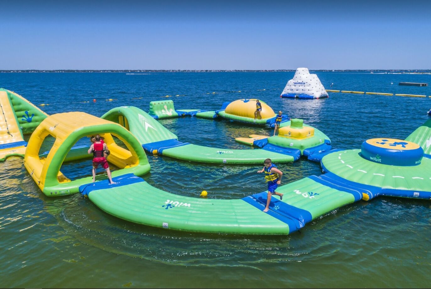 An outdoor water park with various inflatable play structures.
