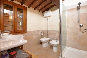 A bathroom with a wooden cabinet, a sink, a bidet, and a shower. - Fienile, Montopoli Val D'Arno, Italy (Montopoli Val D'Arno)