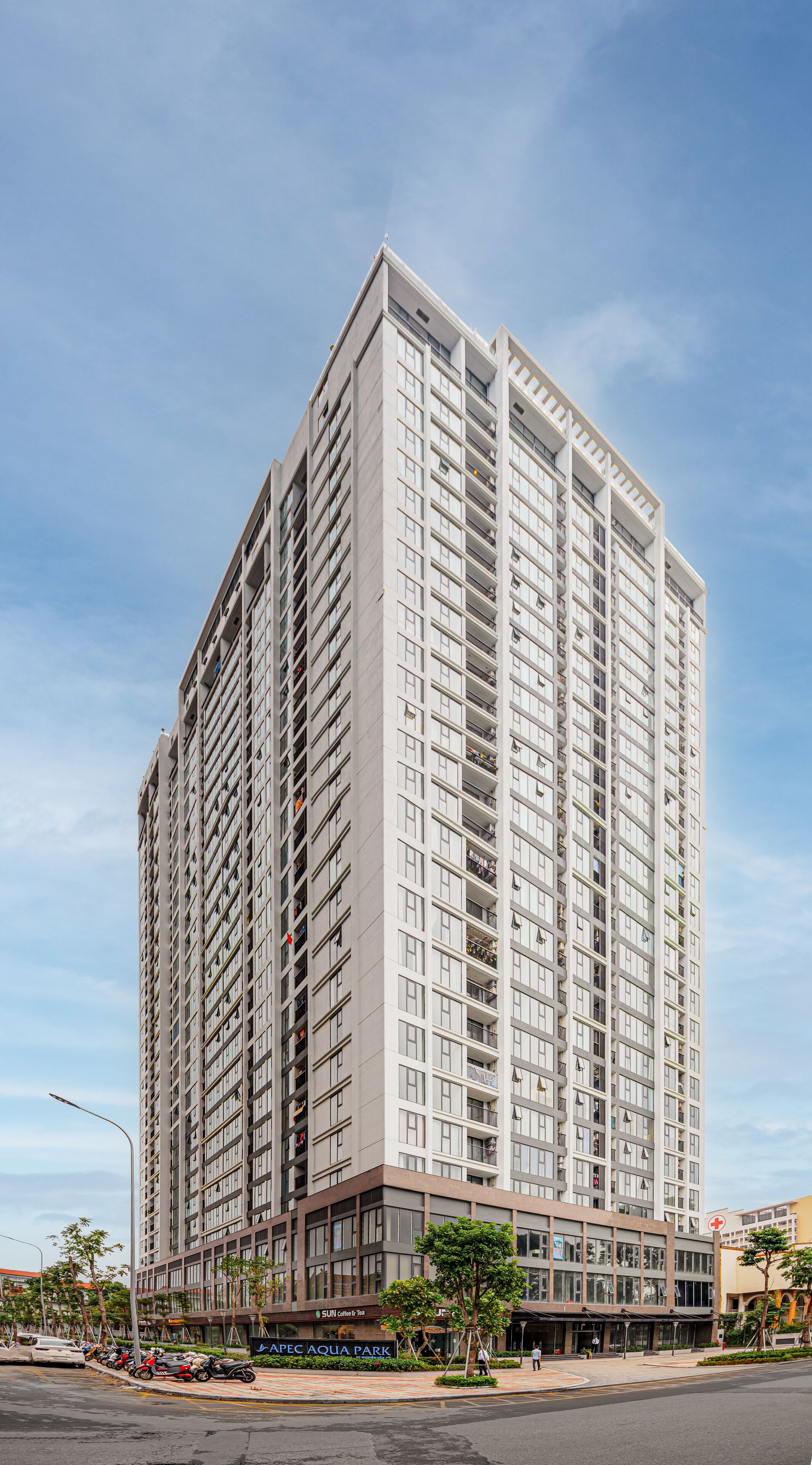 A tall, modern high-rise building with multiple balconies and a flat facade.
