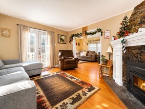 A living room with a fireplace, a sofa, a chair, and a rug.