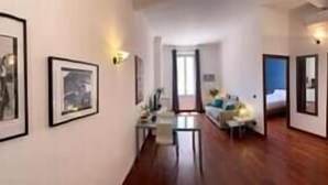 A hallway with framed photographs on the wall, a bicycle, and a dining area in the background. - Remarkable 2-Bed Apartment in Cannes (Cannes)