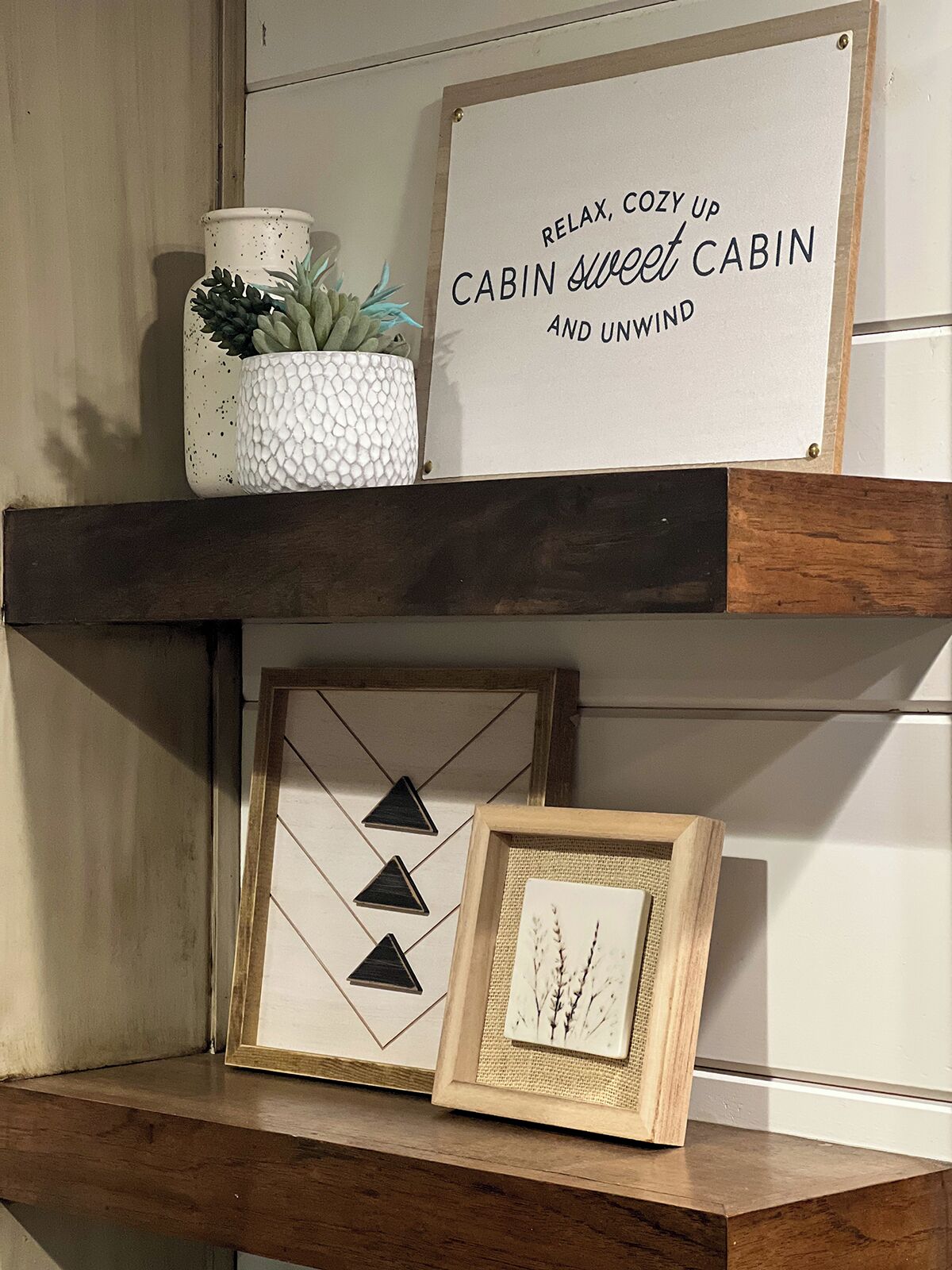 Ein gemütliches Dekor im Blockhaussstil mit einem Schild, auf dem steht: "RELAX, COZY UP CABIN sweet CABIN AND UNWIND" über einem hölzernen Regal.
