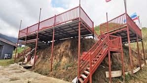 A red metal structure with a staircase and a platform, possibly a temporary construction or access point.