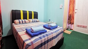 A bedroom with a bed, pillows, a water bottle, and a door with curtains.