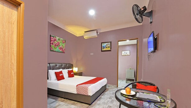 A hotel room with a bed, a small table, a TV, and an air conditioner. - Hotel O Inspire Rooms (Langkawi)