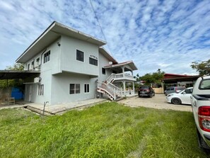 Una casa de dos pisos con un porche cubierto y una escalera que conduce al piso superior.