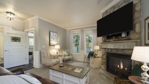 A living room with a fireplace, a television, and a dining area.
