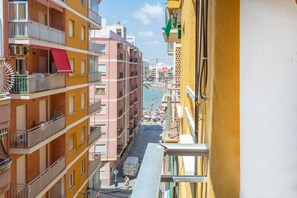 Un edificio de varios pisos con balcones, vista a la playa y cielo despejado.