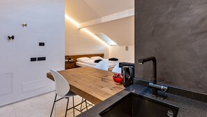 A modern kitchen with a wooden countertop, black sink, and a red bowl. - Studio Apartment 'App 303 Palazzo Cavour' with Mountain View, Wi-Fi and Air Conditioning (Bolzano)