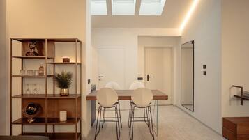Ein modernes Interieur mit Essbereich, Bücherregal und einem Oberlicht.