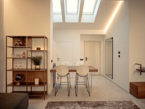 Un intérieur moderne comprenant un coin repas, une bibliothèque et une lucarne.