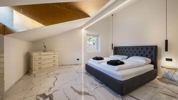 A bedroom with a bed, a dresser, a window, and a ceiling light.