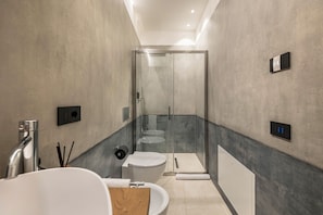 Une salle de bain moderne avec une douche à parois de verre, des toilettes, un lavabo et un miroir.