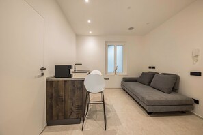 A compact living space with a kitchenette, a sofa, and a dining area.