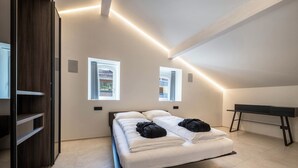Une chambre à coucher moderne, avec un lit, un bureau et deux fenêtres.
