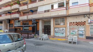 A multi-story building with balconies, a restaurant entrance, and outdoor seating. - Beautiful Vacation Hom "Mtsrat8 "e with Air Conditioning & Terrace (Torrevieja)
