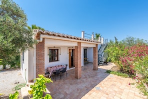 A small house with a patio, a table, and chairs.