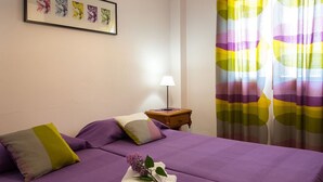 A room with two beds, a nightstand, a lamp, and a framed picture on the wall. - Obelisc-3--------------------- (Can Picafort)