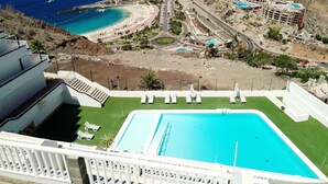 A resort with a swimming pool, beach access, and a view of the ocean.
