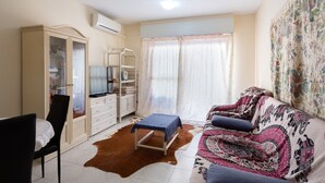 A living room with a sofa, a television, a wardrobe, and a small table. - Beautiful Apartment "Navgts5p33-1" Near the Beach with Pool, A/C & Terrace (Torrevieja)