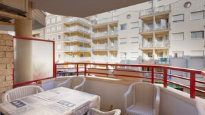 A balcony with a table and chairs, overlooking a building with multiple balconies. - Beautiful Apartment "Navgts5p33-1" Near the Beach with Pool, A/C & Terrace (Torrevieja)