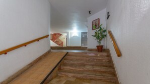 A staircase with a handrail, a potted plant, and a wall-mounted light fixture. - Beautiful Apartment "Navgts5p33-1" Near the Beach with Pool, A/C & Terrace (Torrevieja)