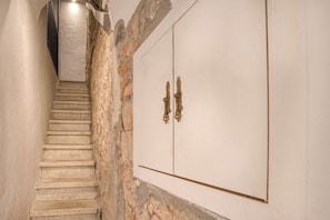 Una scala conduce a una stanza con una porta bianca e maniglie in ottone.