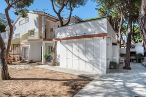 Une maison à deux étages dotée d’un patio couvert, d’un garage et d’un petit jardin.