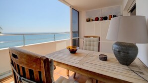 Un balcone con un tavolo in legno, una sedia, una lampada e oggetti decorativi.