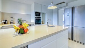 A modern kitchen with a large island, stainless steel appliances, and a hanging pendant light. - Villa Ginevra, perfect for large groups, with Pool, Sauna & Garden (Arona)