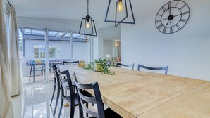 A dining area with a large wooden table, black chairs, and pendant lights. - Villa Ginevra, perfect for large groups, with Pool, Sauna & Garden (Arona)