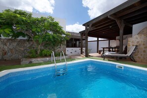 A swimming pool with a stone wall and a pergola. - Holiday Home "Villa Antonia" with Pool, Wi-Fi, Terraces and Garden (Betancuria)