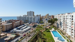 Un hotel moderno con piscina, estacionamiento y vistas al mar.